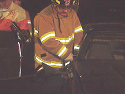 Crest firefighter uses a combination tool during training to remove a vehicle's door.